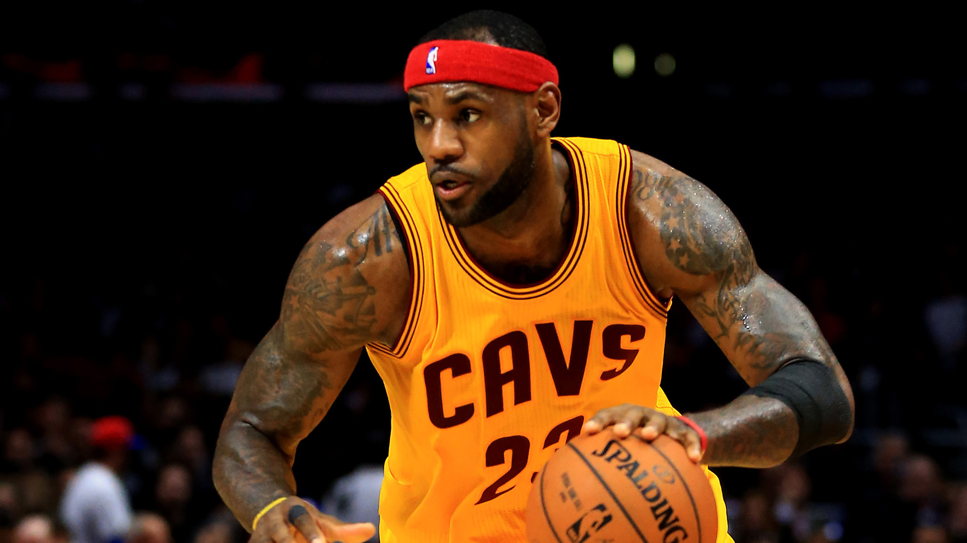 LeBron James Is Tapping Basketball Wearing Yellow Dress And Red Band On Head In A Black Wallpaper HD