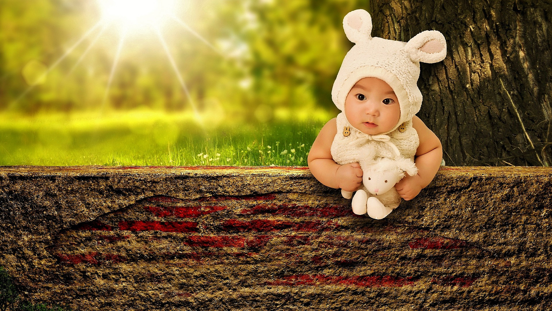 Baby is lying on cement concrete wall with toy in sunbeam Wallpaper hd