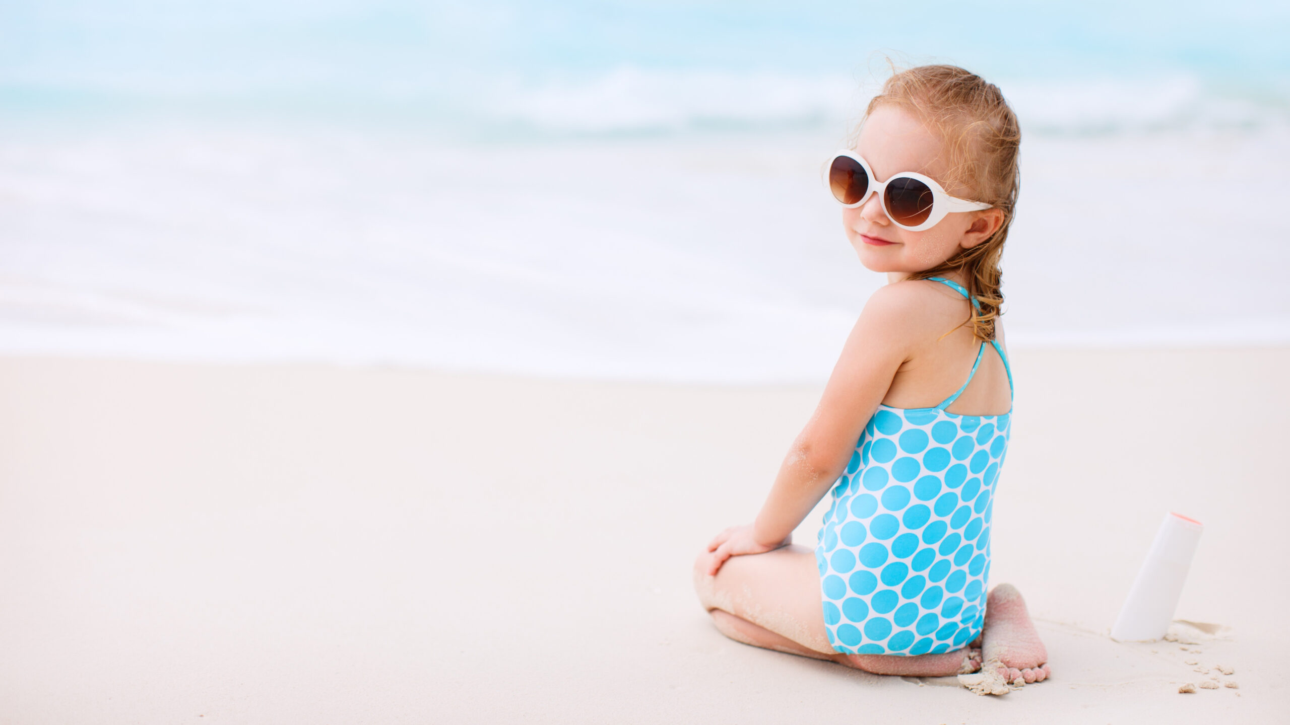 Beautiful Little Girl Is Sitting On Beach Sand Wearing Blue White Dress Goggles In Blur Ocean Wallpaper K K HD
