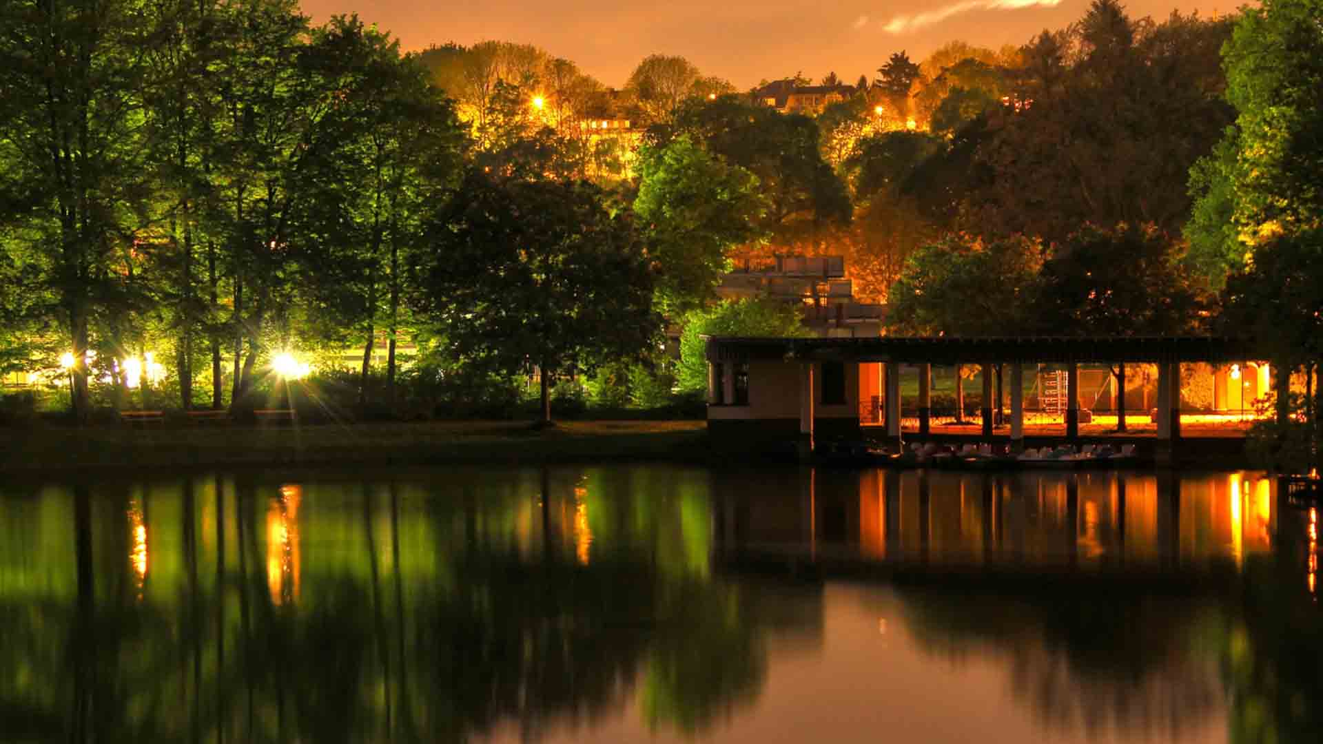 Beautiful Resort With Lights Surrounded By Trees With Reflection On Body Of Water HD Beautiful